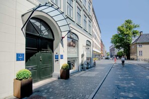 Ein Hotel Eingang mit einem großen Bogenportal, einem Schild mit dem Hotelnamen und einem Fahrrad davor.