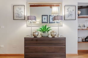 Enter a space of perfect symmetry, featuring a dresser, mirror, and stylish lamps.