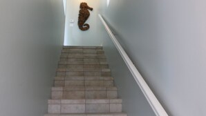 A staircase with a seahorse decoration on the wall. - Villa Sabine by Surfside VR (Pensacola Beach)