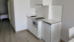 A compact kitchen with white cabinetry, a built-in oven, a dishwasher, and a sink. - Superior Sea View Apartment (APT 2) (Poio)