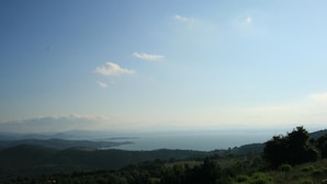 A panoramic view of a coastal landscape with rolling hills and a distant body of water.