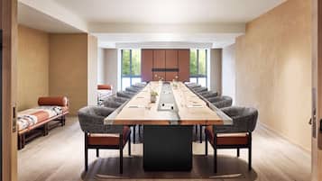 Una sala de conferencias moderna con una mesa larga, asientos cómodos y ventanas amplias.