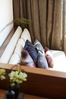 Un sofá con varios cojines en una habitación con paneles de madera y una ventana con cortinas.