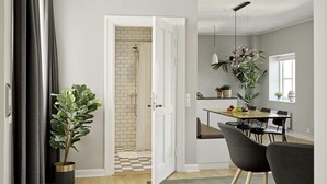 Una cocina moderna con comedor, ducha con piso a cuadros y una planta grande en maceta.