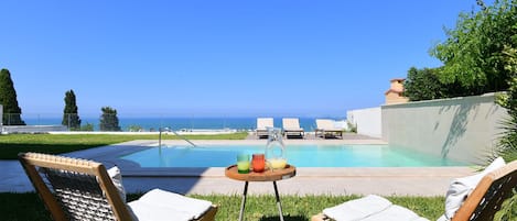 Piscine extérieure, parasols de plage, chaises longues