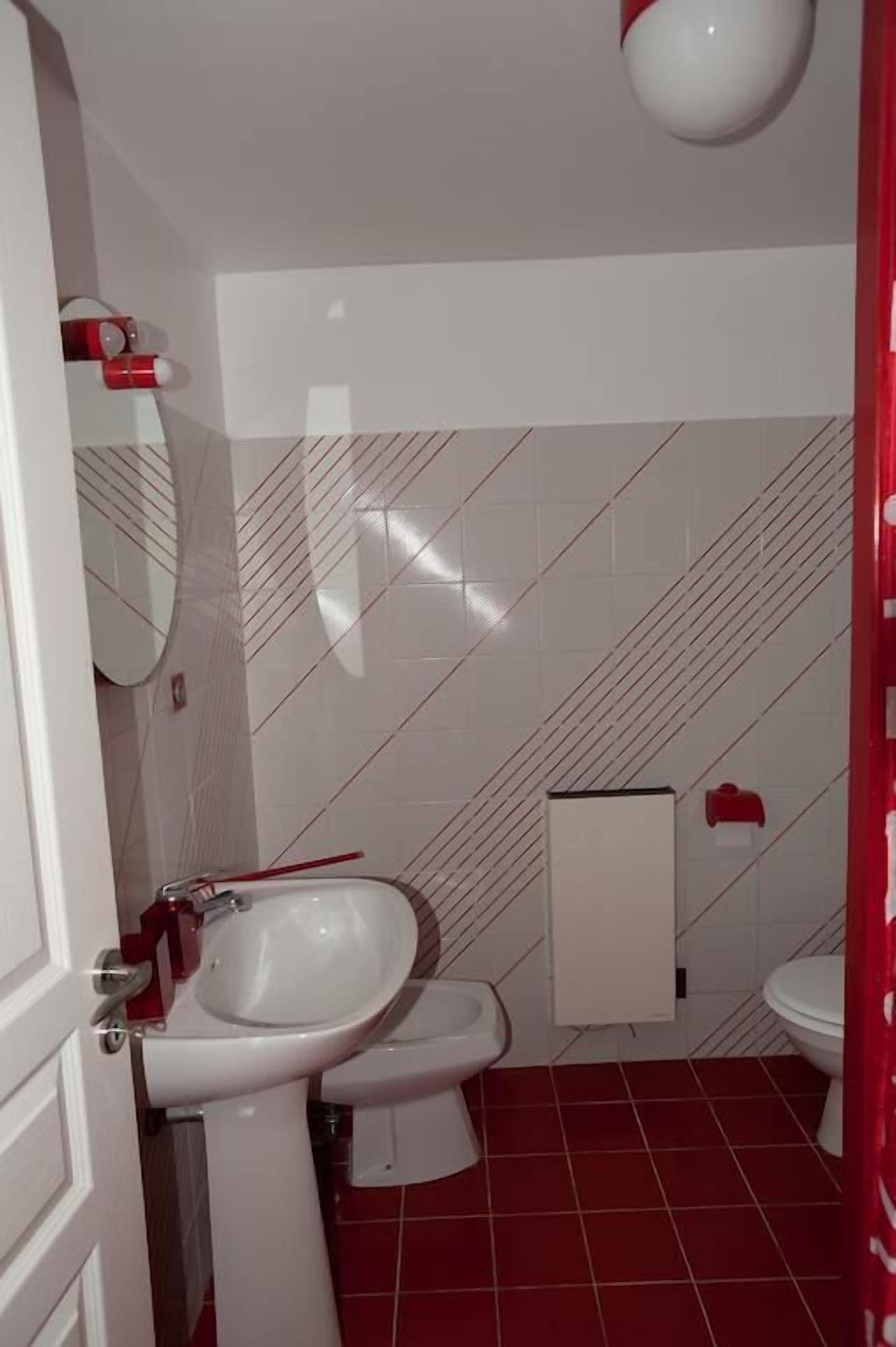 A bathroom with a white sink, a toilet, and a mirror.
