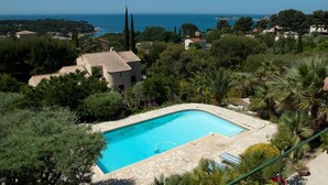 A swimming pool surrounded by lush greenery and a view of the sea. - La Villa Sanary-Sur-Mer (Sanary-sur-Mer)
