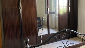 A bedroom with a large wardrobe, a bed with a headboard, and a mirror reflecting part of the room. - Single villa with garden 1300 meters from the sea (Mazara del Vallo)