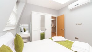 Een moderne slaapkamer met een bed, bureau en een kledingkast.