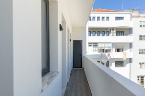 A narrow balcony with a window and a door, leading to an interior space.