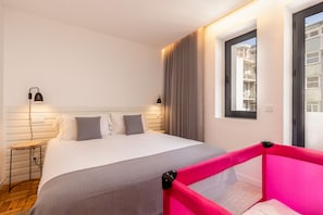 Una camera d'albergo con un letto, lampade sui comodini, una finestra e vista all'esterno.