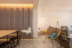 Un soggiorno moderno con zona pranzo, soffitto alto e accogliente angolo salotto.
