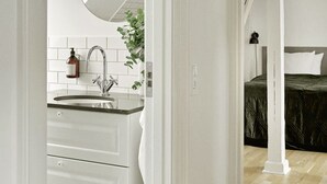 Une salle de bain moderne avec un grand miroir, des carreaux blancs et un lavabo.
