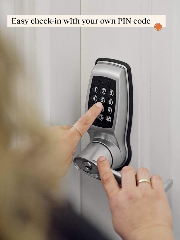 A person using a PIN code to enter a modern door lock.