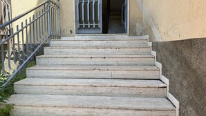 A set of concrete steps leading to a door with a metal gate. - Superb vacation home (Torre archirafi)