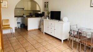 A compact living space with a kitchen, dining area, and a small office.