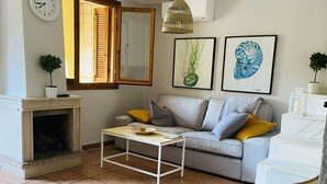 A living room with a fireplace, a sofa, a coffee table, and a chair.