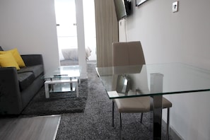 Relax in this stylish living room with a sofa, armchair, and flat-screen TV.