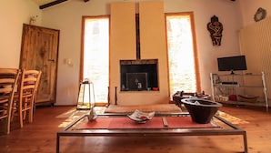 A living room with a fireplace, wooden furniture, and a television.