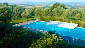 A swimming pool with a view of distant mountains, surrounded by lush greenery.