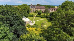 A large estate with multiple buildings, a well-maintained lawn, and a clear sky.