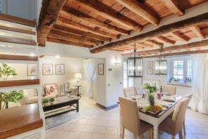 Enjoy a warm meal in this inviting dining area with a traditional table setting, comfortable seating, and beautiful artwork on the walls.