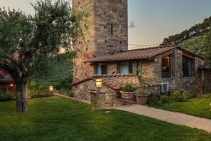 Stunning stone building with a traditional Mediterranean design, surrounded by lush greenery and a serene atmosphere.