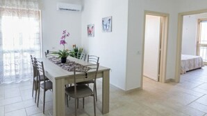A dining area with a table, chairs, and a potted plant. - LAST MINUTE Torre Mozza - Apartment on the sea 21 (Torre Mozza, Lecce)