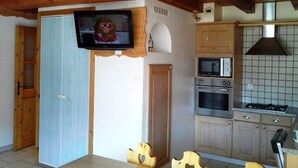 A kitchen with wooden cabinets, a microwave, and a stove.