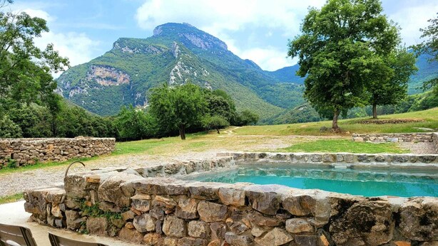 Una piscina de pedra amb vista a una muntanya.