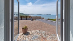 A balcony with a stone floor, a potted plant, and a view of the sea. - 5 bedroom, pet friendly holiday home in  Woolacombe with private hot tub and stunning sea views (Woolacombe)