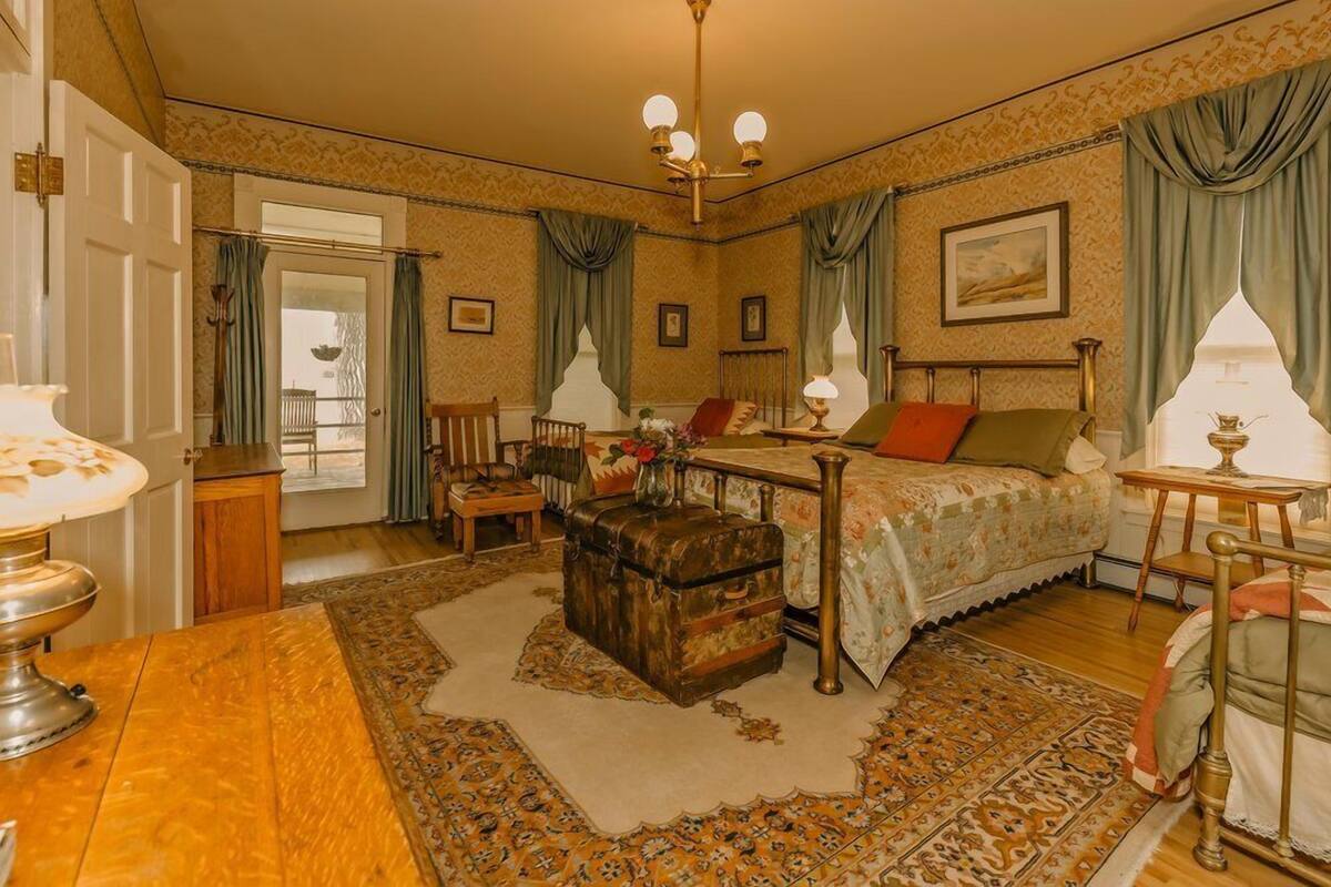 A traditional room with a bed, a wooden chest, a table, and a lamp.