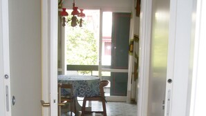Un pasillo con baldosas de diseño que conduce a un comedor con una mesa y sillas.