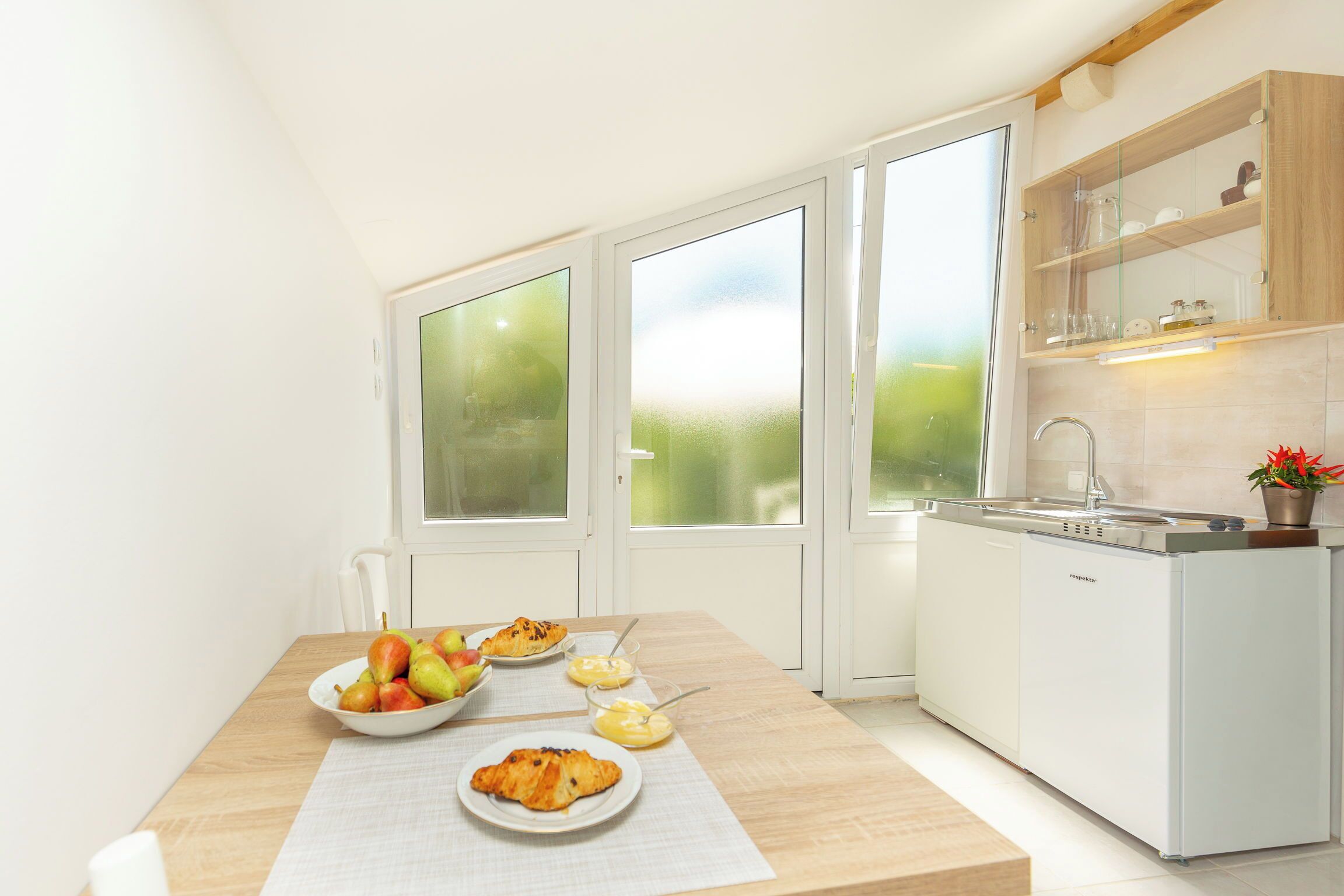 Een moderne keuken met een ontbijt tafel, compleet met fruit en gebak.