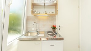 Uma cozinha moderna com pia de aço inoxidável, forno embutido e armário de duas portas.
