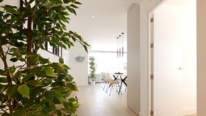 Een modern interieur met een eethoek, een potplant en een witte deur.