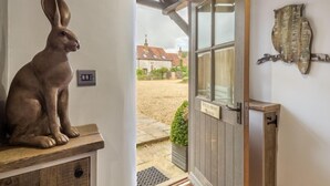A rustic wooden bench with a bronze rabbit sculpture, a wooden door labeled "Hideaway Barn," and a rustic wall decoration. - Hideaway Barn (4), Thornham, Norfolk (Thornham)