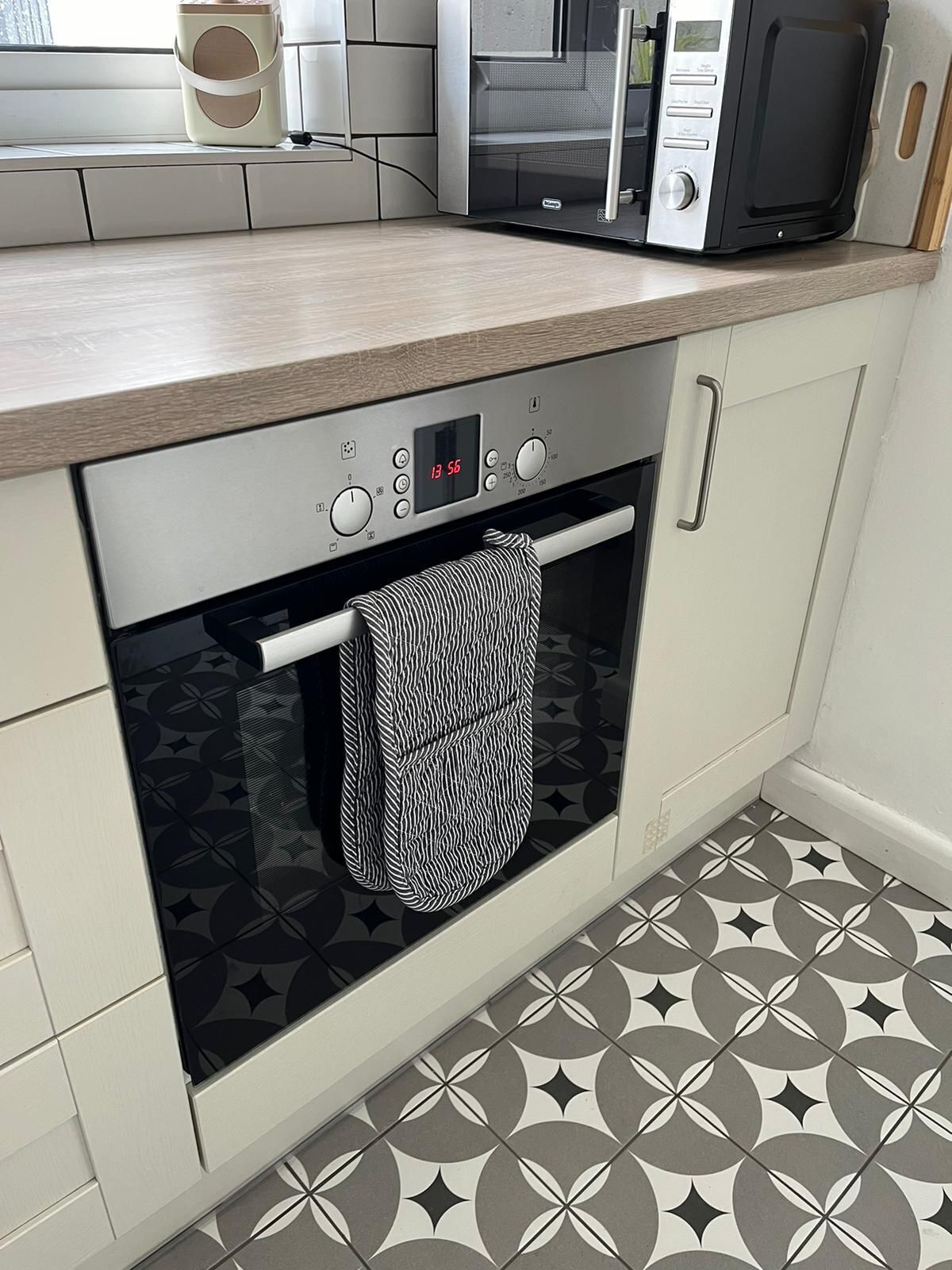 Una cucina con forno a microonde, forno e un appendi asciugamani.
