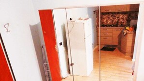 A compact room with a mirrored wardrobe, a small kitchenette, and a wooden floor. - My House of Milan 19 (Milano)