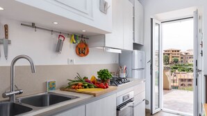 A modern kitchen with a double sink, stainless steel appliances, and a balcony with a city view. - HOUSE WOW panoramic terrace *.* (Siena)