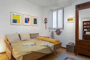 A bedroom with a bed, a wooden dresser, a window, and framed artwork on the wall. - HOUSE WOW panoramic terrace *.* (Siena)
