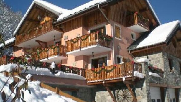 A multi-story wooden chalet with balconies, stone walls, and snow-covered roofs. - country holiday home - VALLOIRE (Valloire)