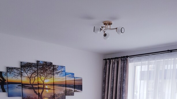 Ein modernes Wohnzimmer mit Ecksofa, Couchtisch und Wandbild.