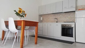Een moderne keuken met witte kasten, een gasfornuis en een spoelbak.