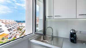 Eine moderne Küche mit Fenster, Spüle und einer Kaffeemaschine.