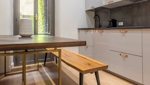 Eine moderne Küche mit Holztisch, Bank und weißen Schränken.