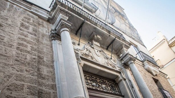 Facciata di un edificio con elementi architettonici classici, tra cui colonne e modanature decorative.