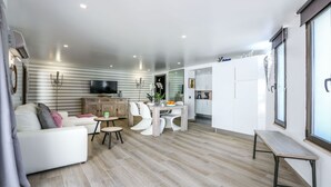 A modern living room with a sofa, dining table, and kitchen area. - ★Luxury 1 Bedroom Apartment, 3 min Walk to the Beach, Albufeira (Albufeira)