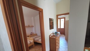 A room with two wooden beds, a dresser, and a painting on the wall.