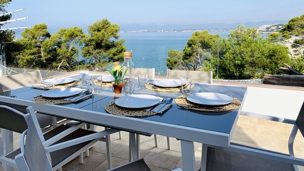 A table set for four with a view of the sea and mountains. - SEA VIEW APT, BEACHFRONT, PARKING, AA/CC, WIFI, LARGE TERRACE (Salou)